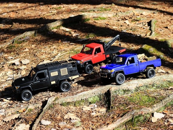 Tri RC autá Toyota Land Cruiser v lese